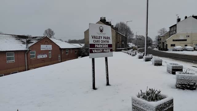 Snow-covered landscape with a sign for Valley Park Care Centre and nearby buildings in Wombwell, Yorkshire.