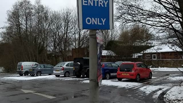 Pay & Display sign indicating "Entry Only" at Church Street Car Park, with parked vehicles and snowy surroundings.