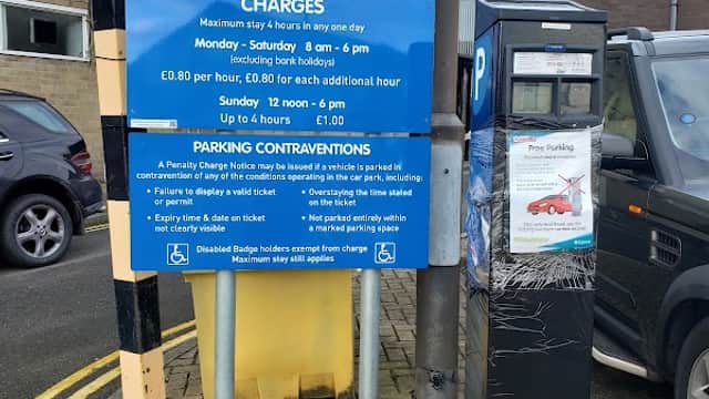 Sign for New North Parade Car Park with parking charges and hours, alongside a parking payment machine.