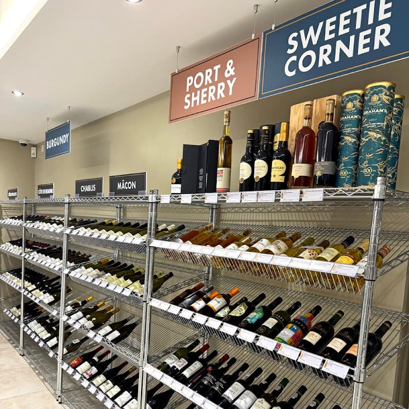 Wine shelves displaying various bottles labeled "Port & Sherry," "Sweetie Corner," "Burgundy," "Chablis," and "Mâcon."