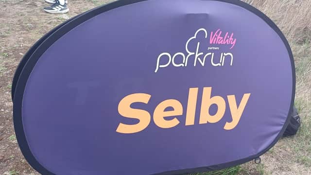 Purple banner displaying "Selby" and "parkrun" logos, set against a grassy area.