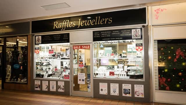 Raffles Jewellers storefront featuring displays of jewelry, a "SALE" sign, and festive decorations.