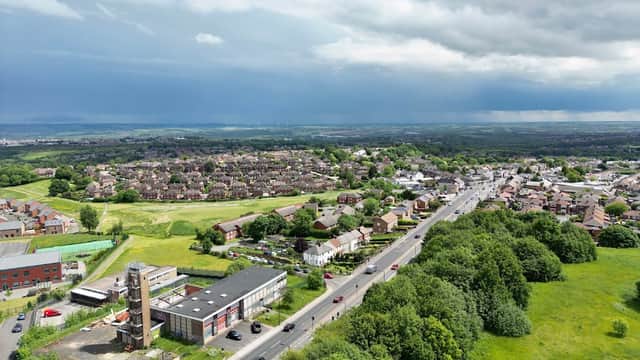 Aerial view of Manor, Yorkshire, showing residential areas, a Pay & Display car park, and green fields under a cloudy sky.