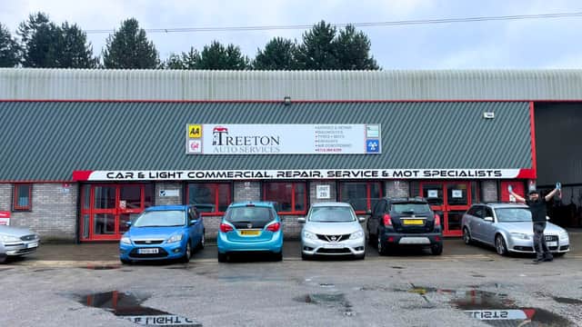 Treeton Auto Services shopfront with parked cars, signage for repair and MOT services, and a cloudy sky above.