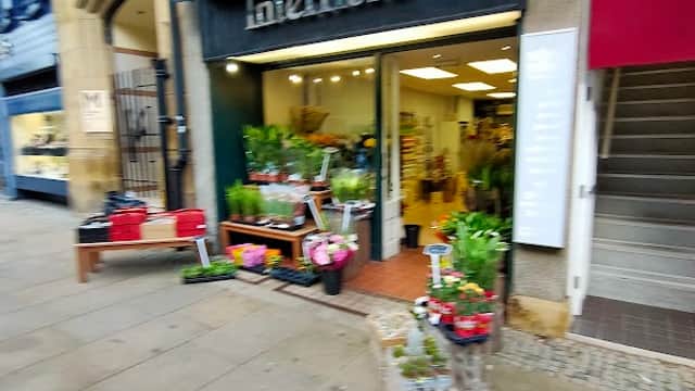 Lockwoods Interflora storefront with flower displays, located in a stone building on a city street in Sheffield.