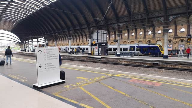 York Railway Station features a spacious platform, signage for directions, and parked trains under a vaulted roof.