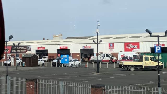 Car park with various vehicles, including vans and cars, along with signage and a fence in Hull, Yorkshire.