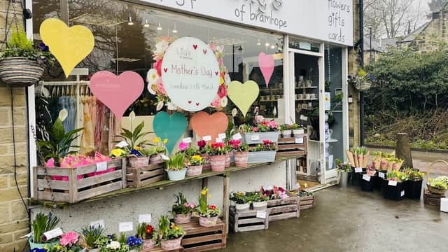 Colorful flower displays and heart-shaped decorations adorn the storefront of Lily's of Bramhope, a florist in Yorkshire.