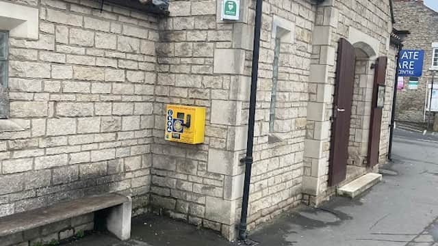 Eastgate car park toilets in Pickering, featuring stone walls, wooden doors, and a yellow emergency phone.