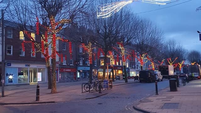 Cycle parking area on Parliament St. South, with festive lights on trees and shops lining the street.