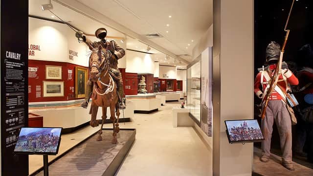 Cavalry exhibit featuring a mounted soldier and a standing infantryman, with historical displays in the background.