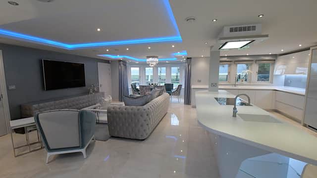 Modern interior featuring sleek furniture, LED lighting, and a spacious open layout with a stylish kitchen and living area.