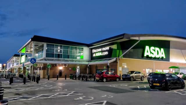 Asda York Superstore exterior at dusk, featuring a large sign, parking spaces, and cars in the lot.