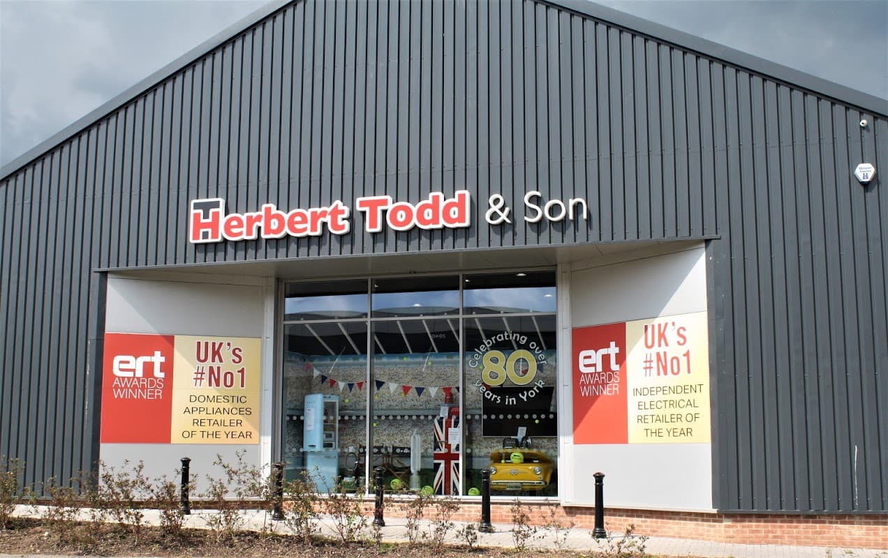Herbert Todd & Son storefront featuring banners for awards, celebrating 80 years, and showcasing home appliances.