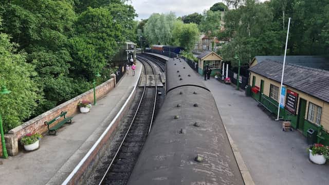 North Yorkshire Moors Railway car park with tracks, greenery, and historic station buildings in Pickering, Yorkshire.