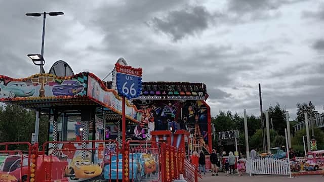 Colorful carnival rides and stalls with a cloudy sky in the background at Junction 32 Shopping Outlet Car Park.