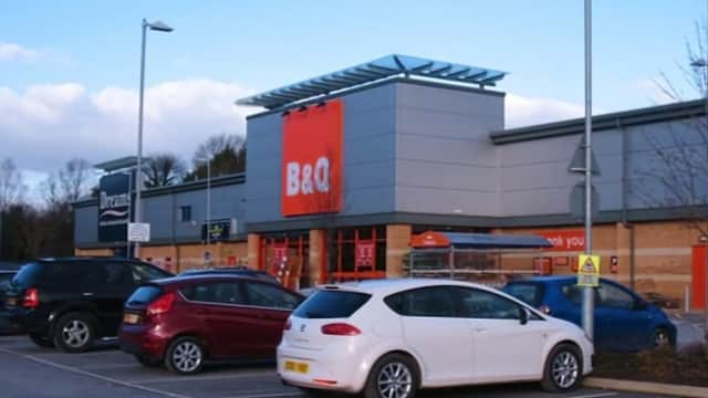 B&Q store exterior with parking lot, featuring various cars and a clear blue sky in Harrogate, Yorkshire.