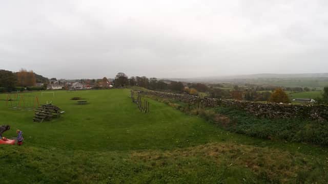 Leyburn Playground features swings, climbing structures, and grassy areas with a scenic view of the surrounding countryside.