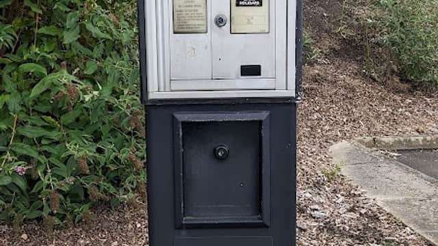 Parking meter with payment options, surrounded by greenery and gravel, in Wakefield Old Road Car Park, Dewsbury.