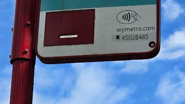 Bus stop sign for Kiln Park, with blue sky and clouds in the background, indicating routes to Garforth and Leeds.