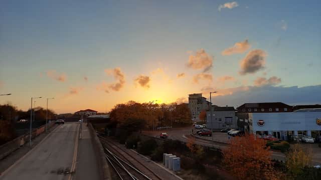 Sunset over a car park with autumn trees, buildings, and railway tracks in Thornaby, Yorkshire.