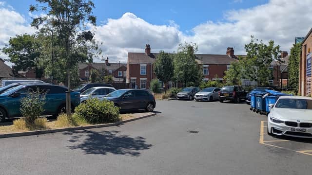 South Parade Short Stay Car Park with parked cars, greenery, and blue bins under a partly cloudy sky.