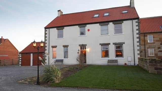 Townend Farm Bed & Breakfast, a two-story building with a red roof, surrounded by grass and a lantern in Easington, Yorkshire.