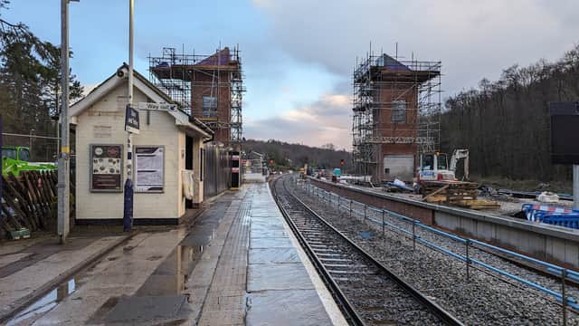 Park and Ride station with construction scaffolding, tracks, and a small building beside a wet platform in Greenhill, Yorkshire.