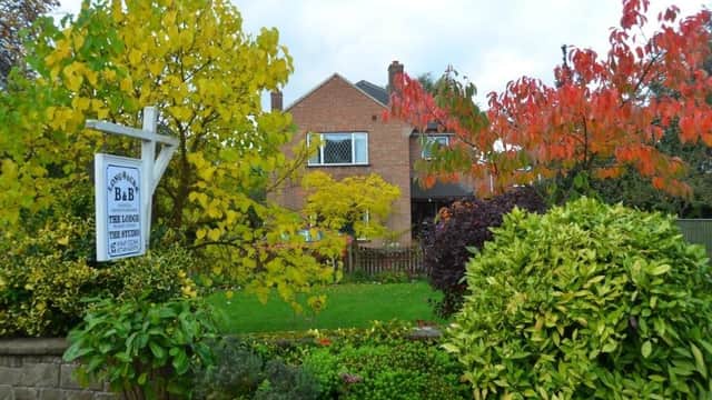 Long Acre Self-Catering Apartments surrounded by colorful autumn foliage and a lush garden in Sowerby, North Yorkshire.