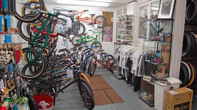 BMX bikes and apparel displayed in a bright shop, with shelves of bike parts and accessories in Sheffield.
