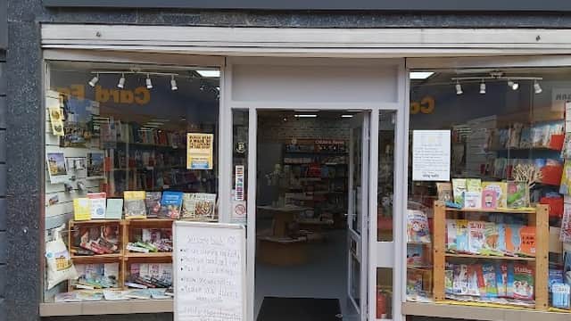 Entrance of Brighouse Books featuring bookshelves, a signboard, and a welcoming display.