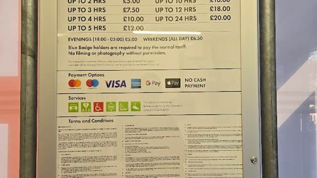 Pricing and services sign for Q-Park Durham Road, detailing parking rates and payment options. Open 24/7.
