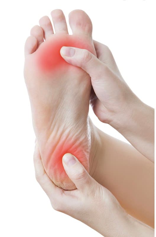 A person gently massaging the sole of a foot, highlighting a red area indicating discomfort or pain.