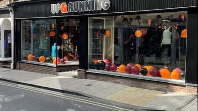 Sports shop storefront with large windows displaying colorful balloons and athletic gear in York, Yorkshire.