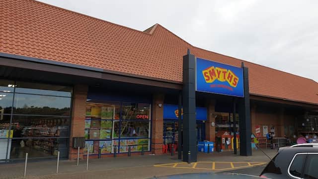 Smyths Toys Superstores storefront with a red and yellow sign, open entrance, and shoppers outside in York.