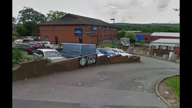 Pay & Display parking area with cars, a Starbucks sign, and a building in the background in Norristhorpe, Yorkshire.