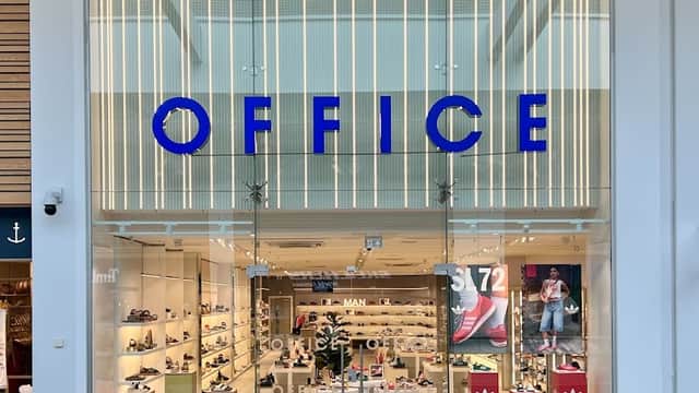 Bright storefront of OFFICE Meadowhall, showcasing various shoes with vibrant signage and displays inside.
