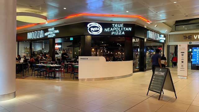 Mazza restaurant sign, indoor seating area with tables, and vibrant lighting in the White Rose Shopping Centre.
