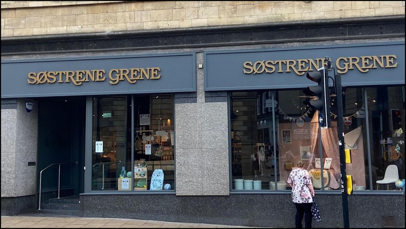 Two large storefronts of Søstrene Grene with elegant signage, showcasing home decor and furniture items.