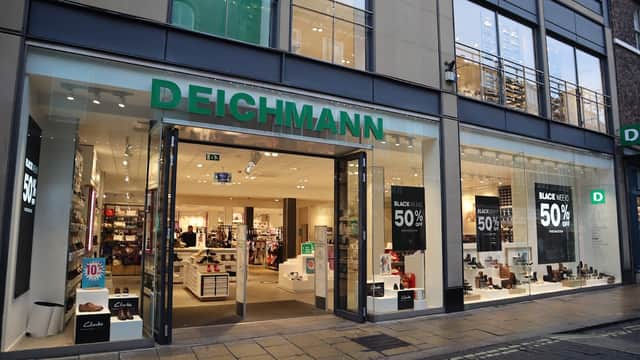 DEICHMANN shoe shop with large glass entrance, sale signs, and various shoe displays inside.