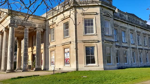Historic hotel with grand columns, large windows, and manicured lawns set against a clear blue sky in Yorkshire.
