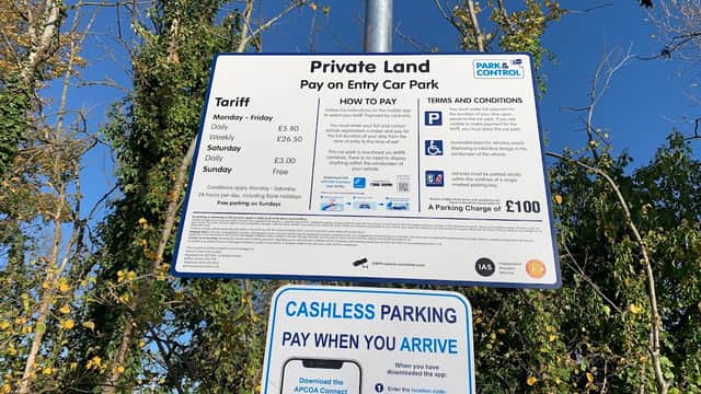 Sign detailing parking tariffs, payment methods, and terms for Skillings Lane car park in Brough, surrounded by trees.