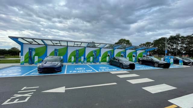 MFG Charging Station with multiple electric vehicle chargers and parked cars under a cloudy sky in Thirsk, Yorkshire.