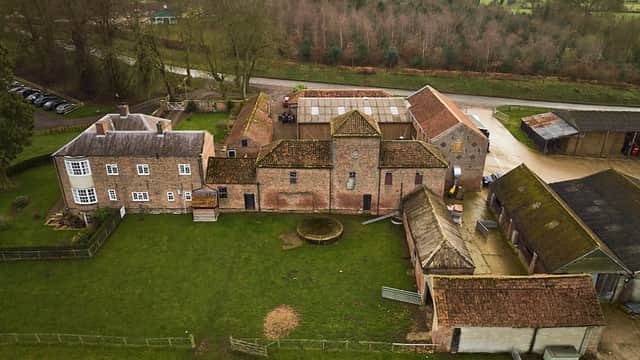 Aerial view of Cundall Lodge Farm featuring buildings, green fields, and a gravel path in North Yorkshire.
