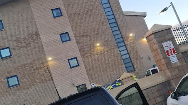 Pay & Display car park with a police station in the background; a parked van with contact information visible.
