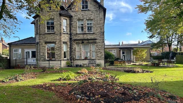 Victorian-style care home surrounded by gardens, trees, and outdoor seating in Barlby, Yorkshire.