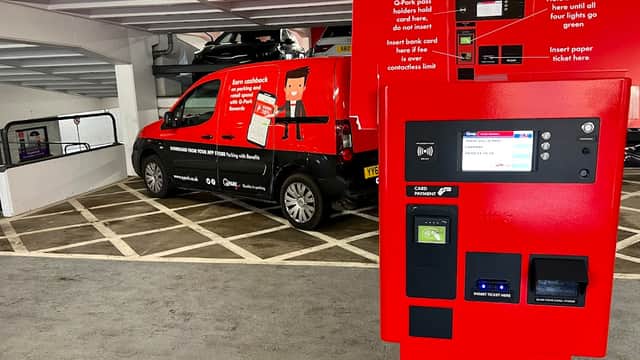 Pay & Display machine with instructions, parked vehicle, and marked parking spaces in Q-Park St Johns Centre, Leeds.