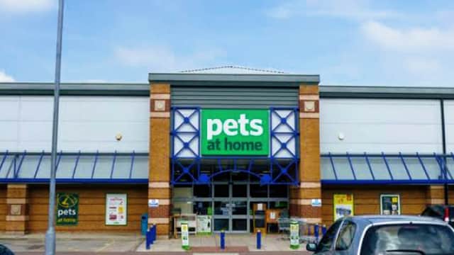 Pets at Home store entrance with blue accents and signage, surrounded by a parking lot and clear sky.