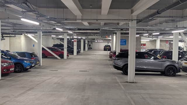 Spacious underground car park with parked cars and bright overhead lighting at New Era Square, Sheffield.