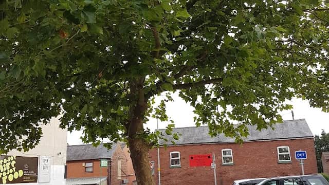 Main Street Car Park in Garforth, featuring parked cars, a tree, and nearby buildings with a "Free Parking" sign.